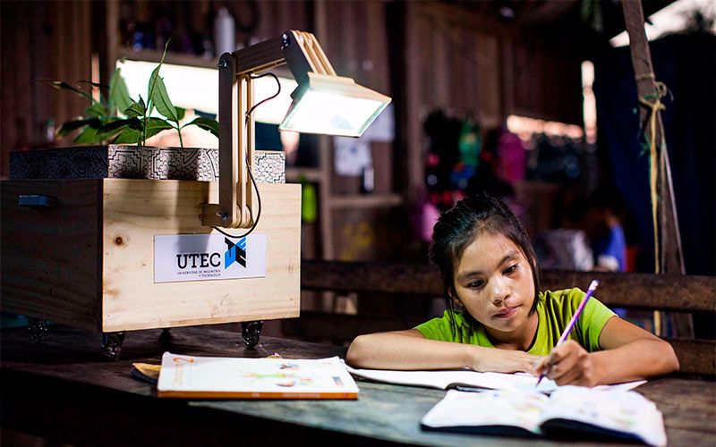Mädchen macht Hausaufgaben vor der Pflanzenlampe