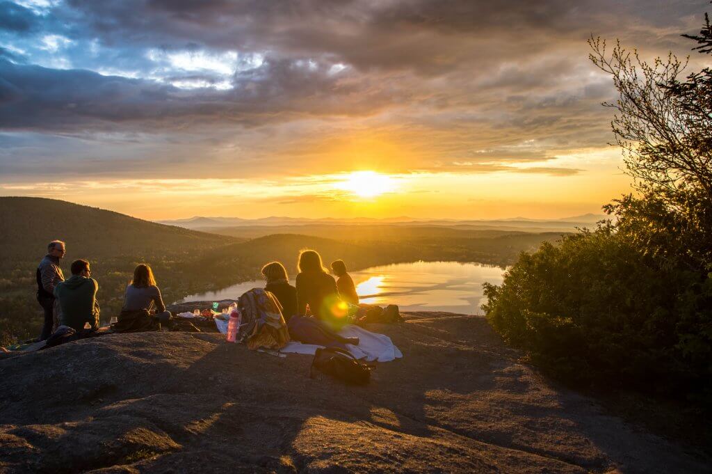 eine Gruppe von Freunden macht ein Picknick im Sonnenuntergang