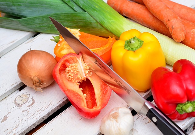 Gemüse und Gemüseschnipsel auf einem Tisch mit Messer, das gerade schneidet